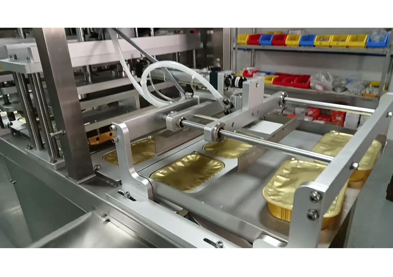 Aluminum foil tray continuous film pick-up and sealing configuration