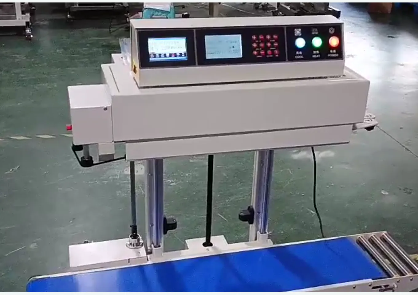 Close-up of heating/cooling control panel, sealing head, and conveyor load-bearing section for heavy bag sealing equipment