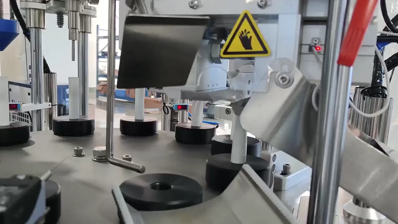Close-up of unlabeled white tubes running between turret carriers and tail sealing station